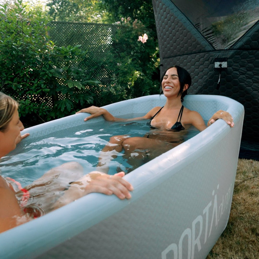 Two women relaxing in a portable hot tub outdoors.